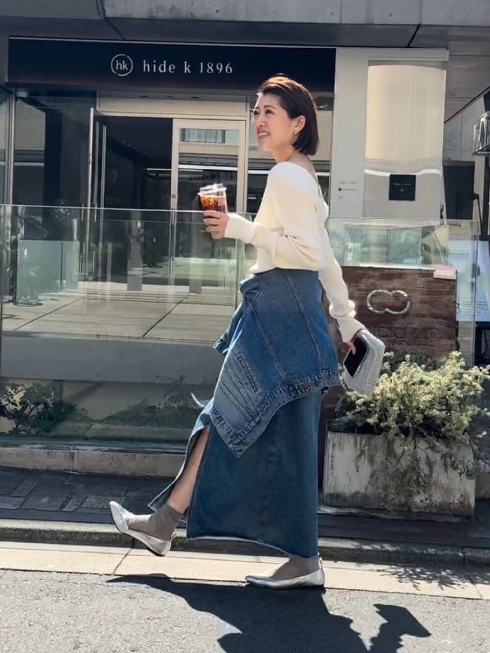 ブルー系のデニムジャケット、ブルー系のデニムスカート、グレー系のニット/セーターを着用したレディースの春コーディネートの3枚目の写真