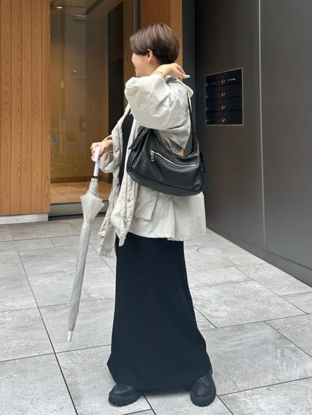 ブラック系のワンピース、グレー系のマウンテンパーカーを着用したレディースの秋コーディネートの2枚目の写真