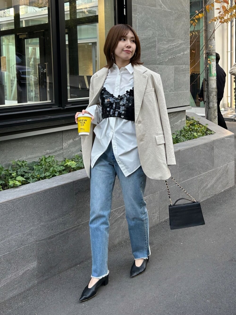 ホワイト系のシャツ/ブラウス、ベージュ系のテーラードジャケット、ブラック系のキャミソールを着用したレディースの冬コーディネートの2枚目の写真