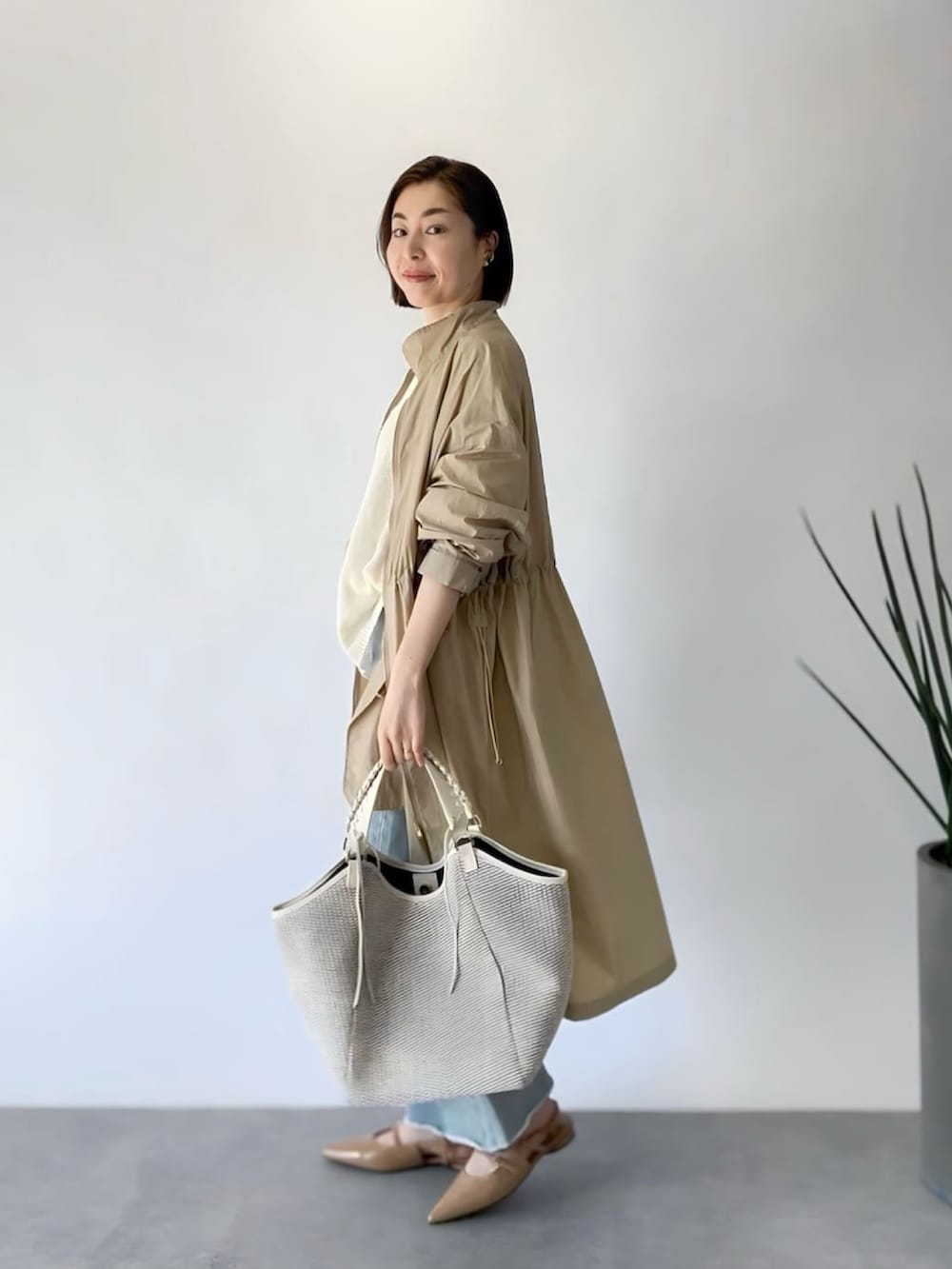 ホワイト系のニット/セーター、ベージュ系のジャケット/アウター、ホワイト系のショルダーバッグを着用したレディースの春コーディネートの2枚目の写真