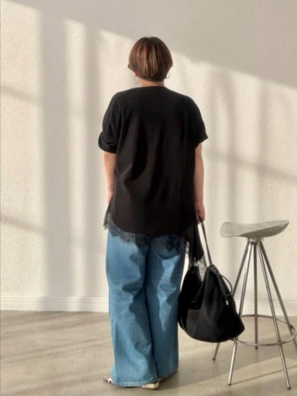 ブラック系のTシャツ/カットソー、ブラック系のキャミソール、ブルー系のデニムパンツを着用したレディースの春コーディネートの2枚目の写真