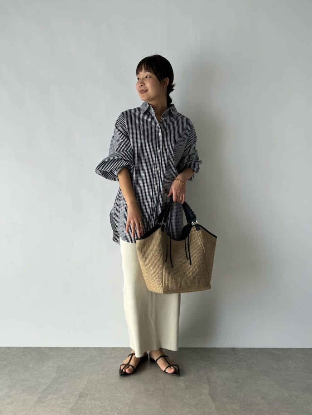 ブラック系のシャツ/ブラウス、ホワイト系のスカート、ブラック系のショルダーバッグを着用したレディースの春コーディネートの3枚目の写真