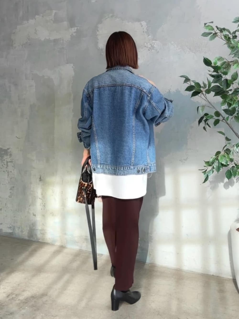 ブルー系のデニムジャケット、ホワイト系のTシャツ/カットソー、ブラック系のブーツを着用したレディースの冬コーディネートの3枚目の写真