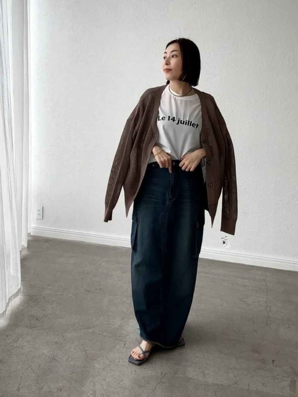 ホワイト系のシャツ/ブラウス、ブラウン系のカーディガン/ボレロ、ブルー系のデニムスカートを着用したレディースの春コーディネートの3枚目の写真