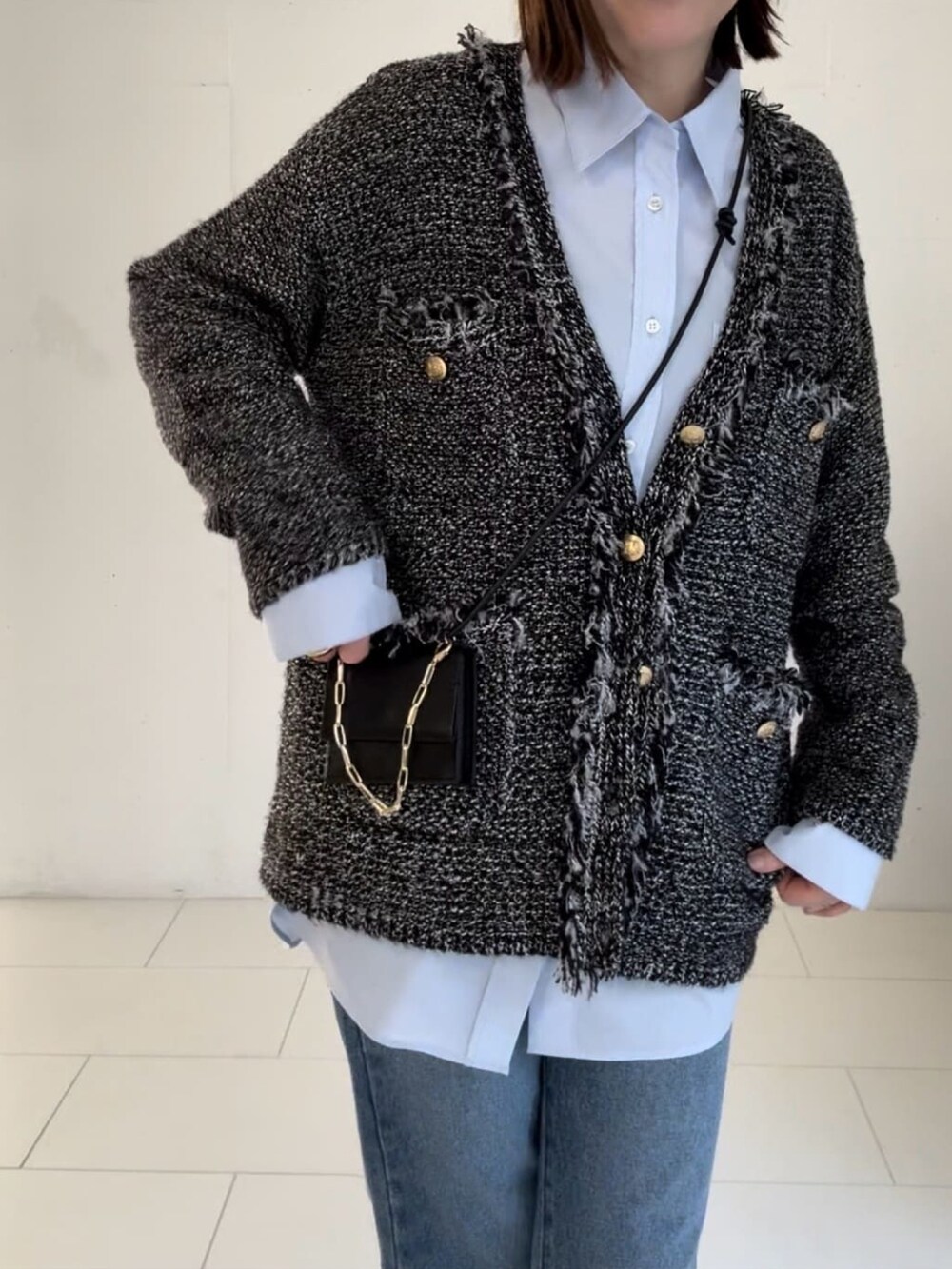 ブラウン系のカーディガン/ボレロ、ブルー系のデニムパンツ、グリーン系のショルダーバッグを着用したレディースの冬コーディネートの2枚目の写真