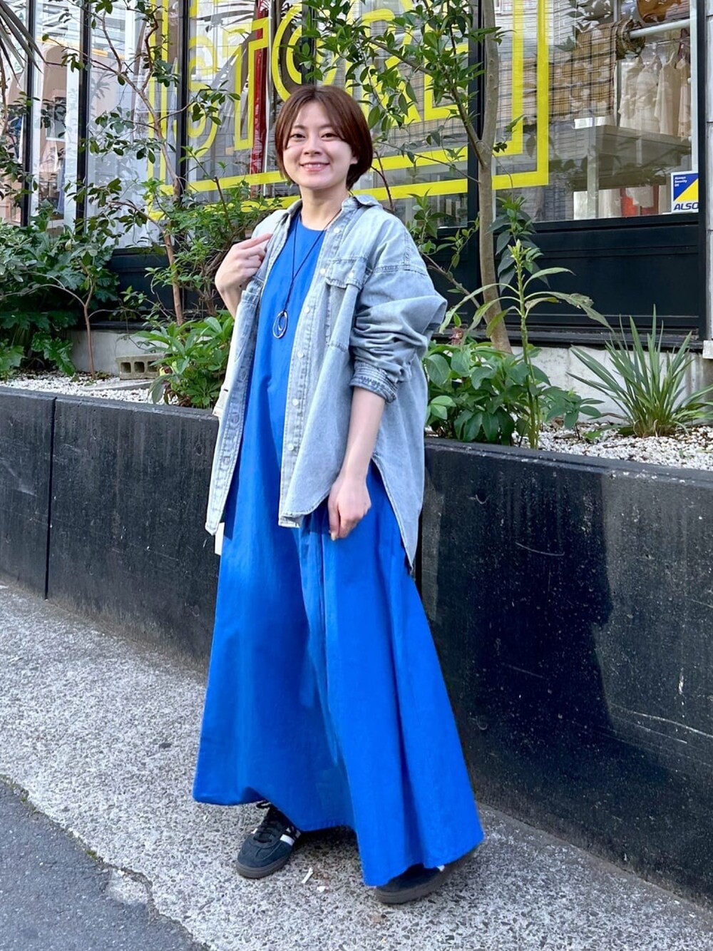 ブルー系のシャツ/ブラウス、ブルー系のワンピース、シルバー系のネックレスを着用したレディースの春コーディネートの2枚目の写真