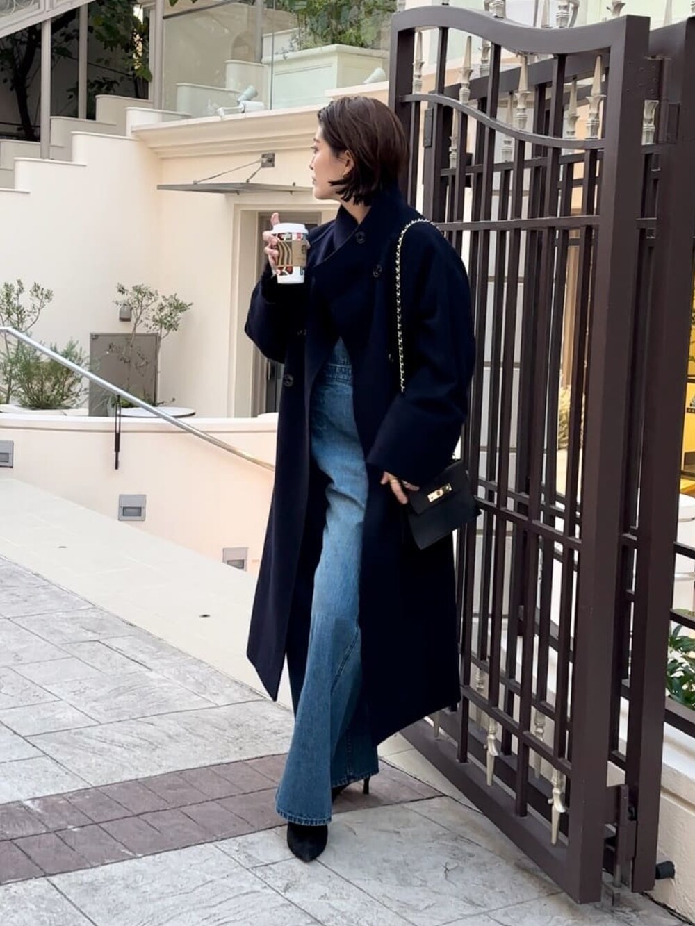 ブルー系のその他アウター、ブラック系のブーツ、ブルー系のジャンパースカートを着用したレディースの冬コーディネートの2枚目の写真