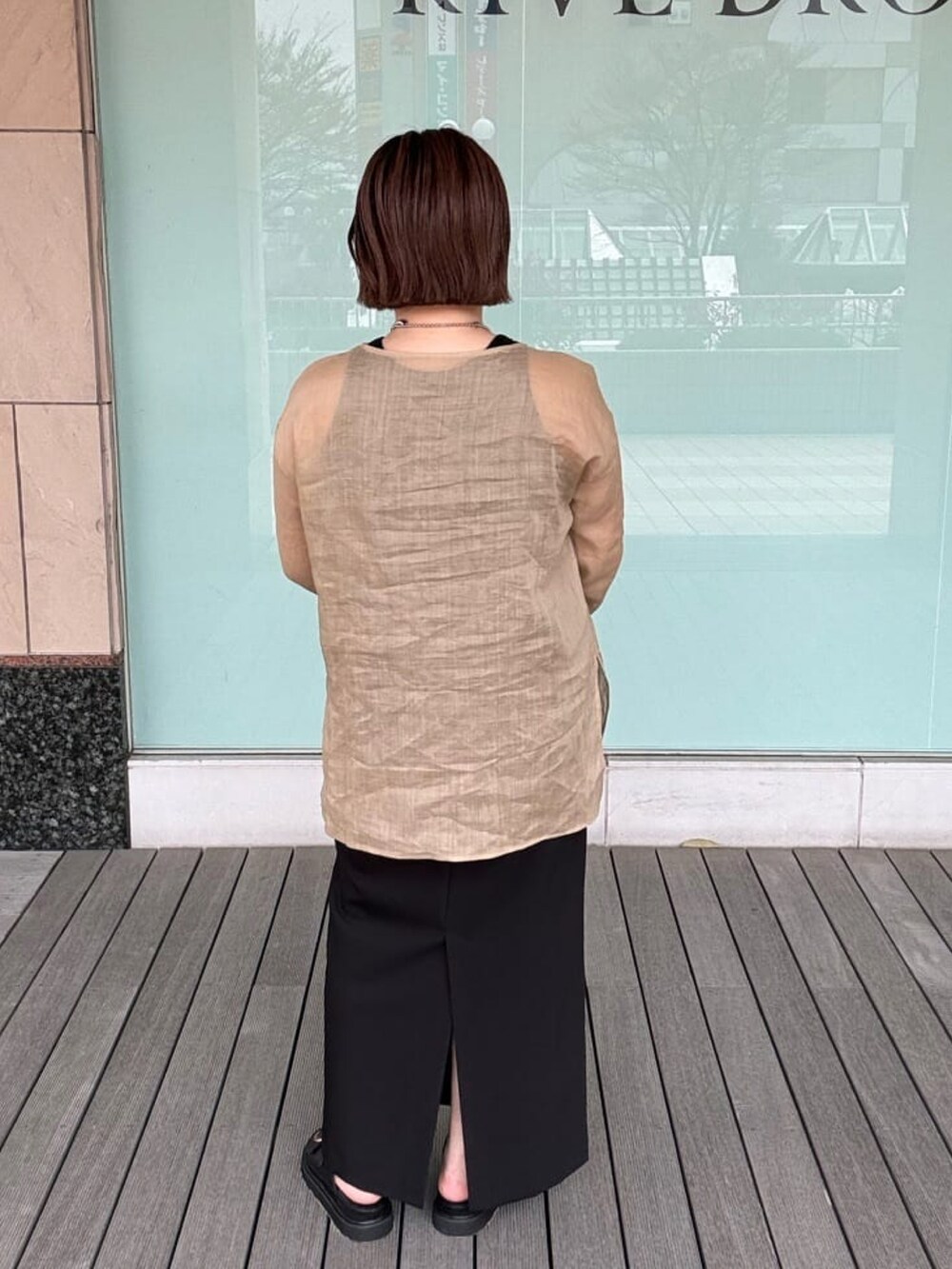 ベージュ系のシャツ/ブラウス、ゴールド系のショルダーバッグ、ブラック系のタンクトップを着用したレディースの春コーディネートの2枚目の写真