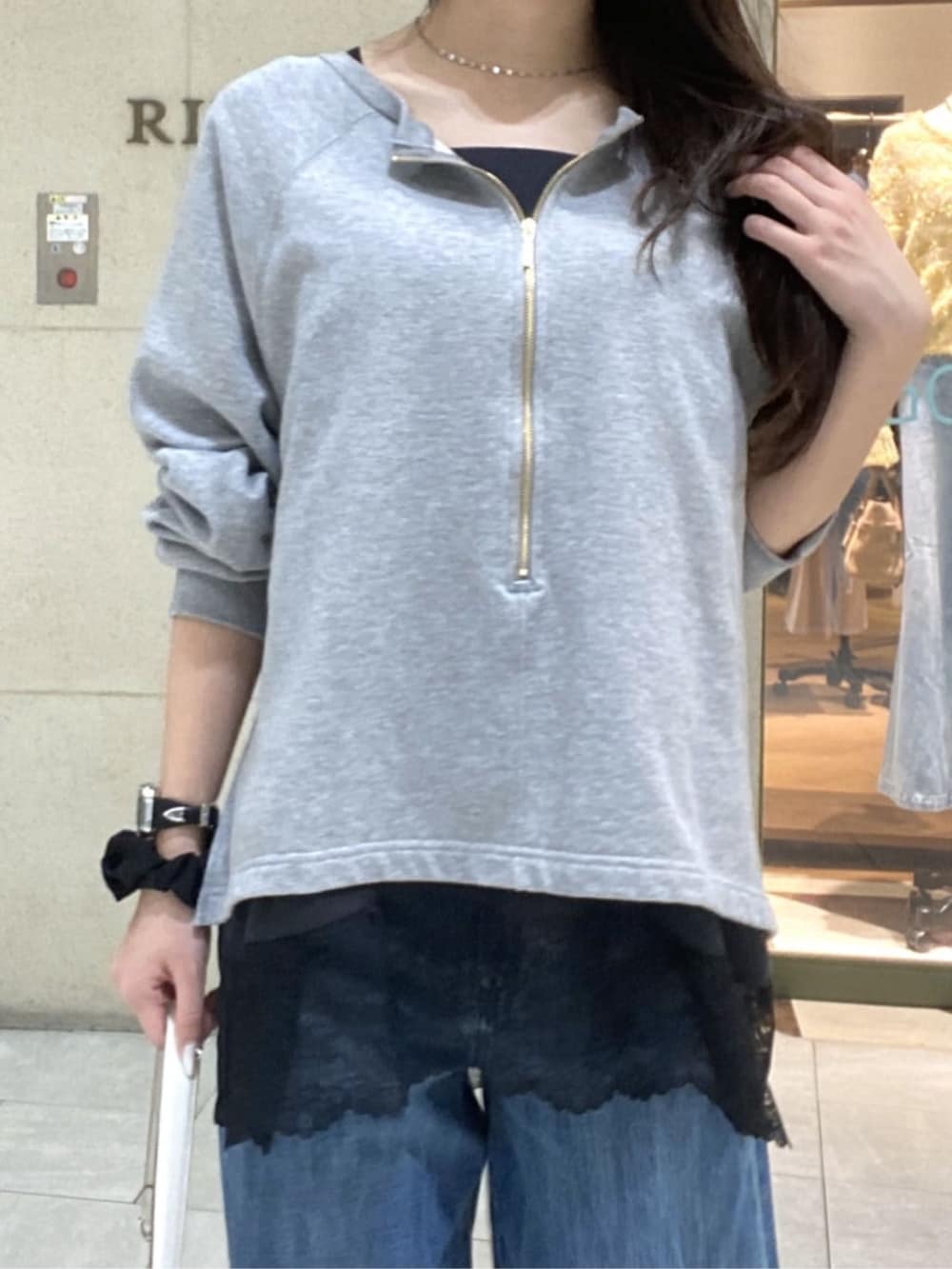 グレー系のスウェット、ブラウン系のキャミソール、ホワイト系のショルダーバッグを着用したレディースの春コーディネートの4枚目の写真