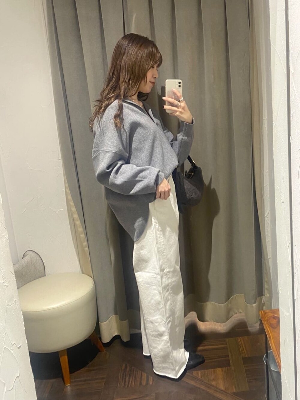 グレー系のニット/セーター、ホワイト系のデニムパンツ、ブラック系のローファーを着用したレディースの冬コーディネートの2枚目の写真