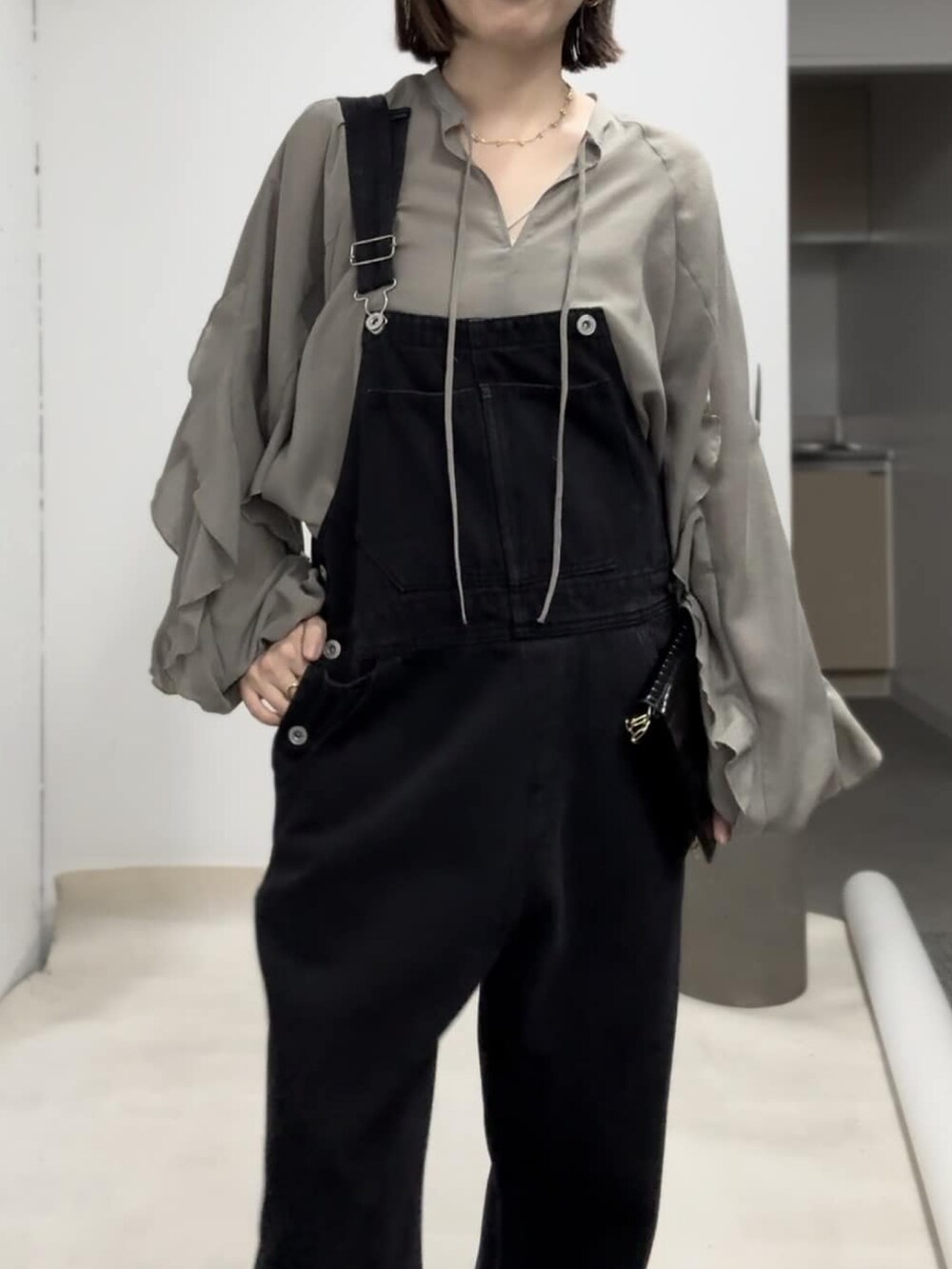 グリーン系のシャツ/ブラウス、ブラック系のサロペット/オーバーオール、ブラック系のサンダルを着用したレディースの春コーディネートの4枚目の写真