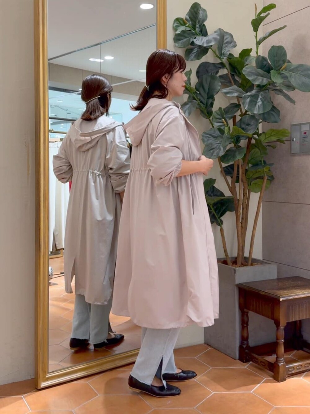 ブラウン系のニット/セーター、ベージュ系のモッズコート、ブラック系のボストンバッグを着用したレディースの秋コーディネートの2枚目の写真