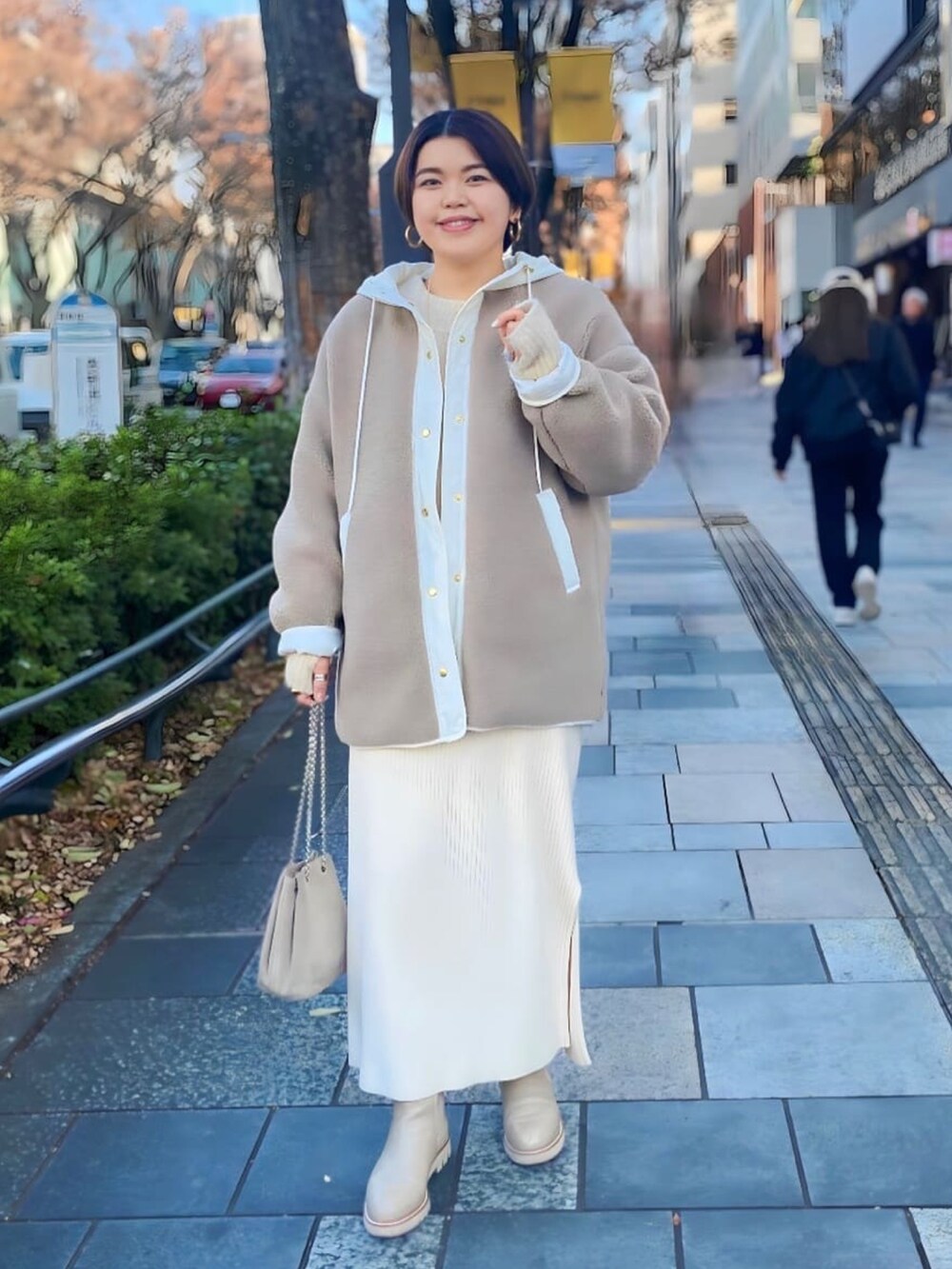 ベージュ系のその他アウター、ブラック系のワンピース、ベージュ系のブーツを着用したレディースの冬コーディネートの2枚目の写真