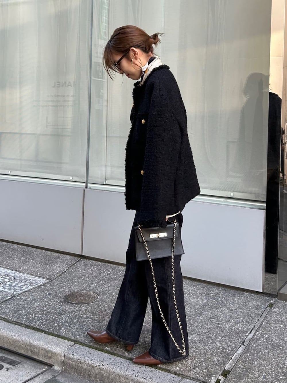 ブラック系のその他アウター、ホワイト系のニット/セーター、ブルー系のデニムパンツを着用したレディースの冬コーディネートの2枚目の写真