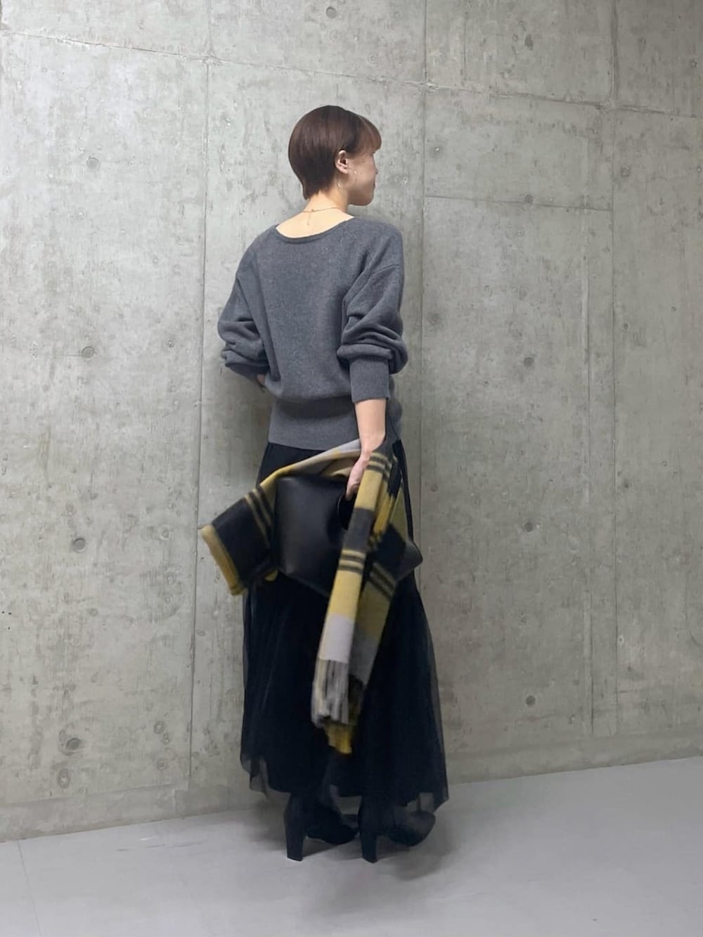 グレー系のニット/セーター、ブラック系のスカート、ブラック系のブーツを着用したレディースの秋コーディネートの3枚目の写真