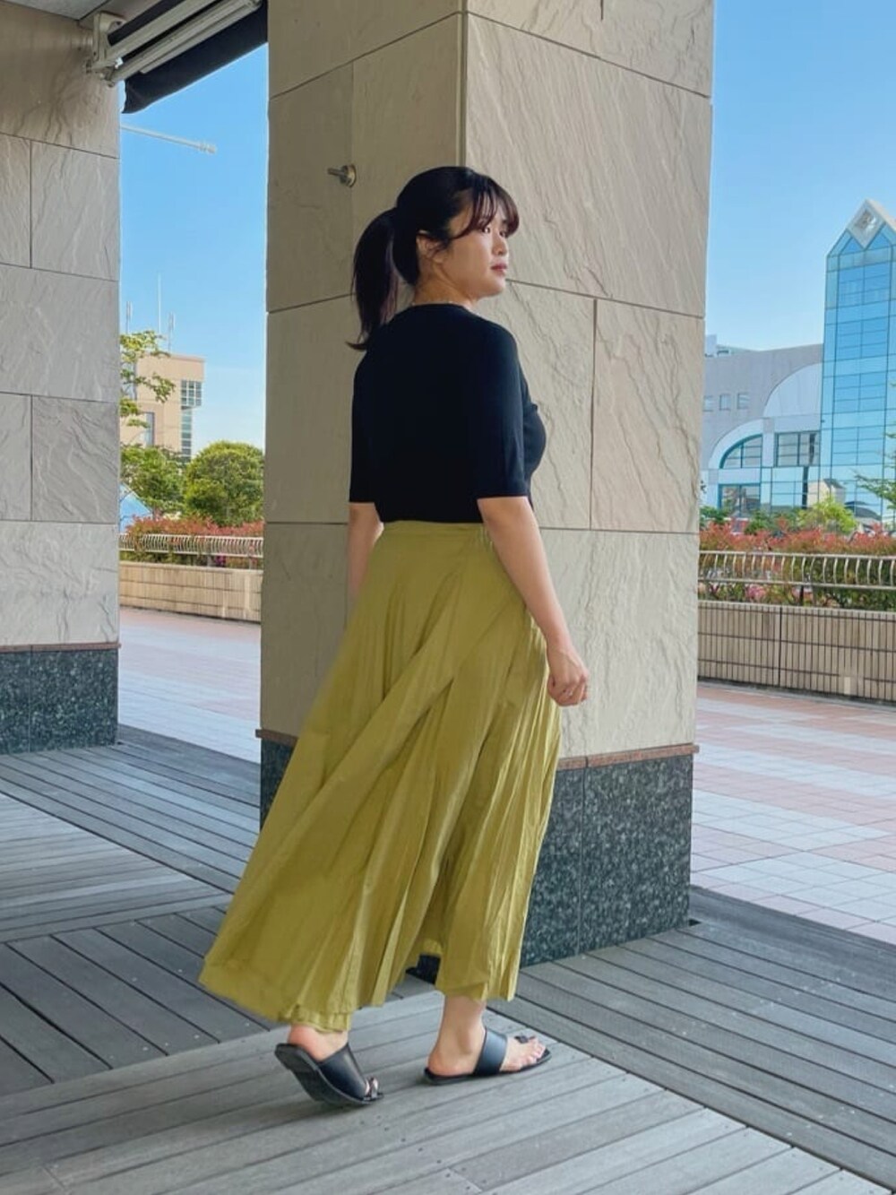 ブラック系のTシャツ/カットソー、グリーン系のスカートを着用したレディースの春コーディネートの3枚目の写真