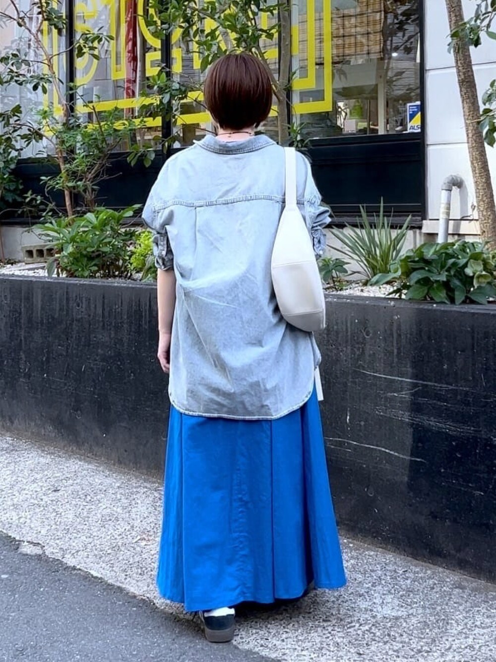 ブルー系のシャツ/ブラウス、ブルー系のワンピース、シルバー系のネックレスを着用したレディースの春コーディネートの4枚目の写真