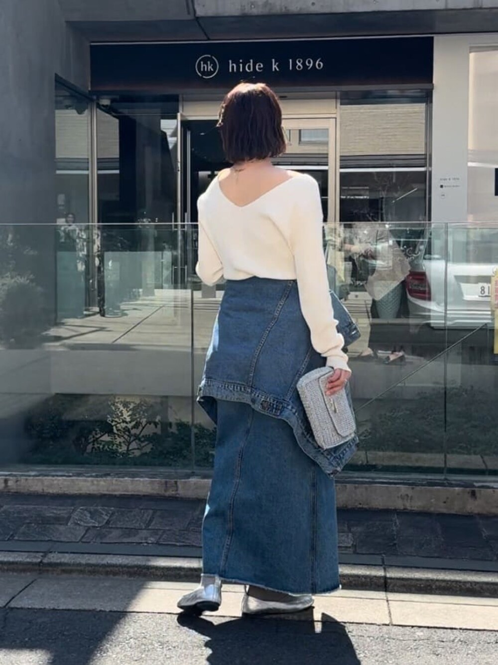 ブルー系のデニムジャケット、ブルー系のデニムスカート、グレー系のニット/セーターを着用したレディースの春コーディネートの4枚目の写真