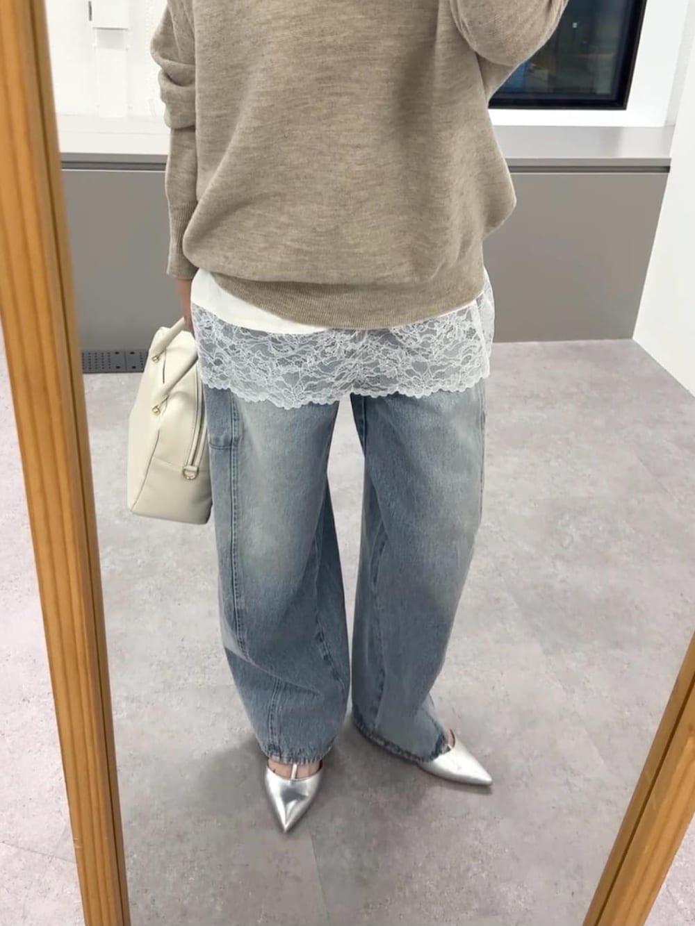 ベージュ系のニット/セーター、ホワイト系のキャミソール、ホワイト系のボストンバッグを着用したレディースの冬コーディネートの5枚目の写真