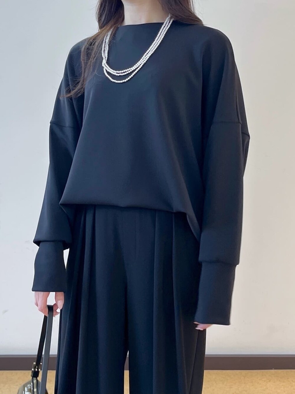 ブラック系のスラックス、ブラック系のTシャツ/カットソー、グリーン系のショルダーバッグを着用したレディースの春コーディネートの5枚目の写真