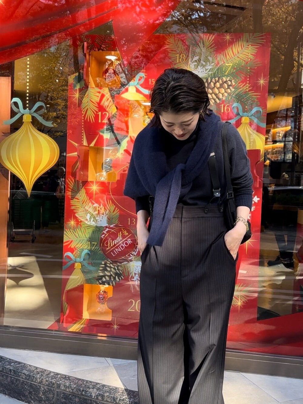 ブルー系のニット/セーター、ブラック系のスラックス、ブラック系のローファーを着用したレディースの冬コーディネートの4枚目の写真