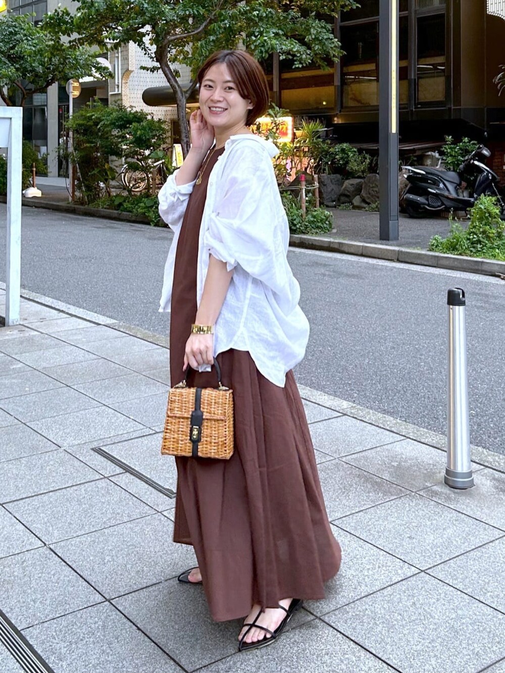 ホワイト系のシャツ/ブラウス、ブラウン系のワンピース、ブラック系のサンダルを着用したレディースの春コーディネートの2枚目の写真