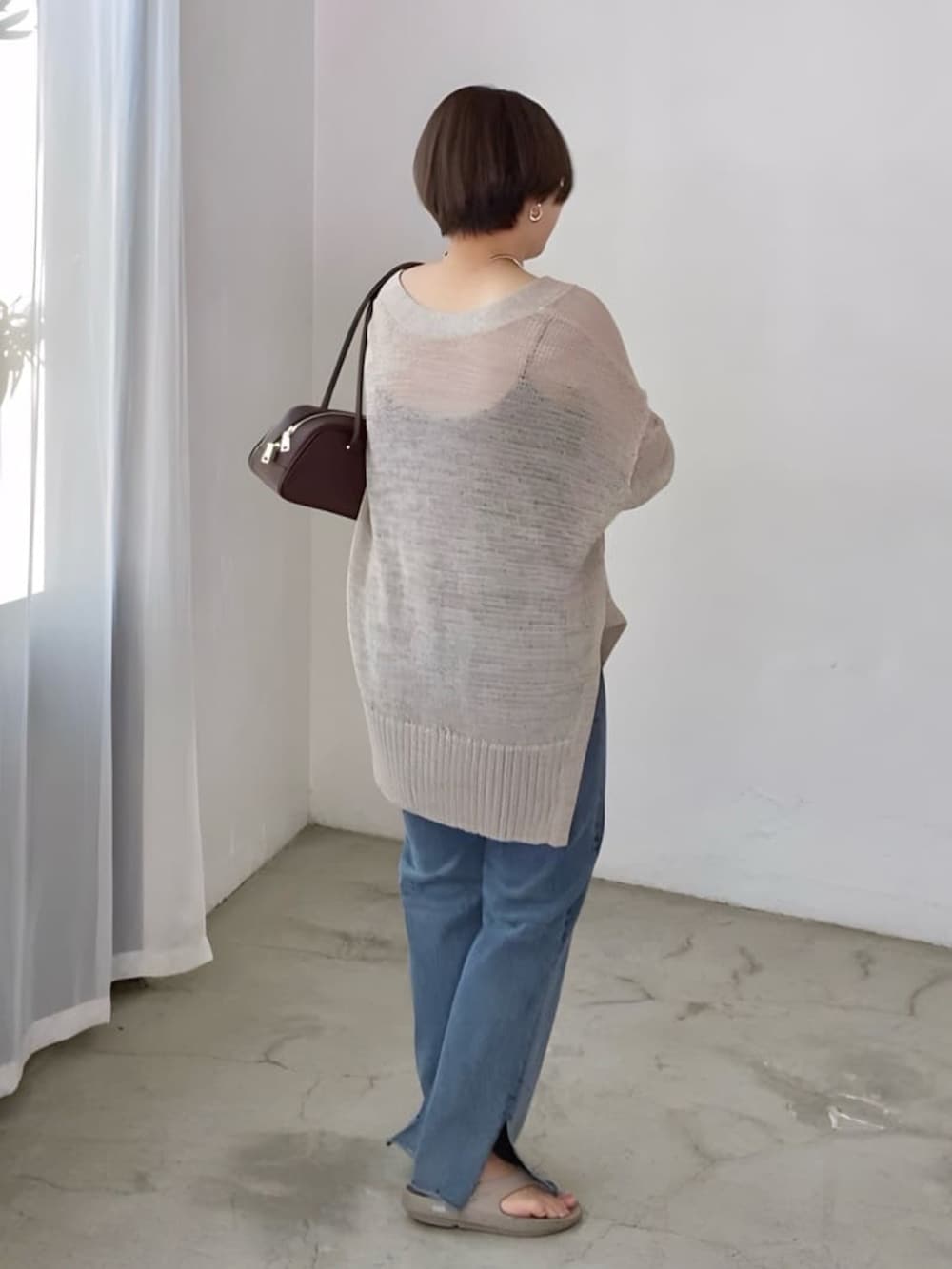 ブラウン系のショルダーバッグ、グレー系のカーディガン/ボレロ、ブルー系のデニムパンツを着用したレディースの夏コーディネートの2枚目の写真