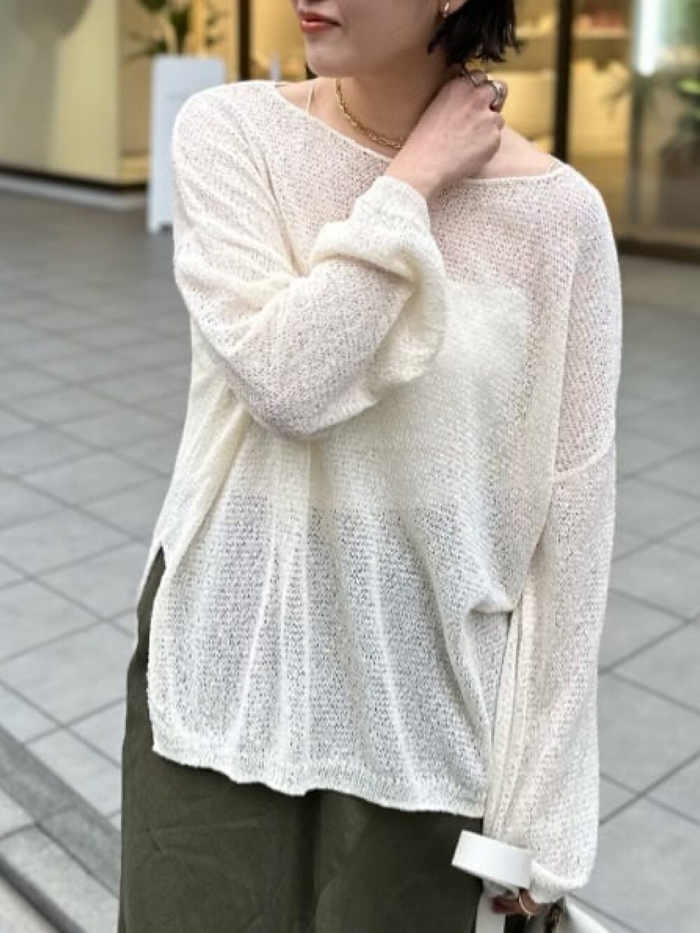 ホワイト系のニット/セーター、ホワイト系のキャミソール、グリーン系のスカートを着用したレディースの春コーディネートの5枚目の写真