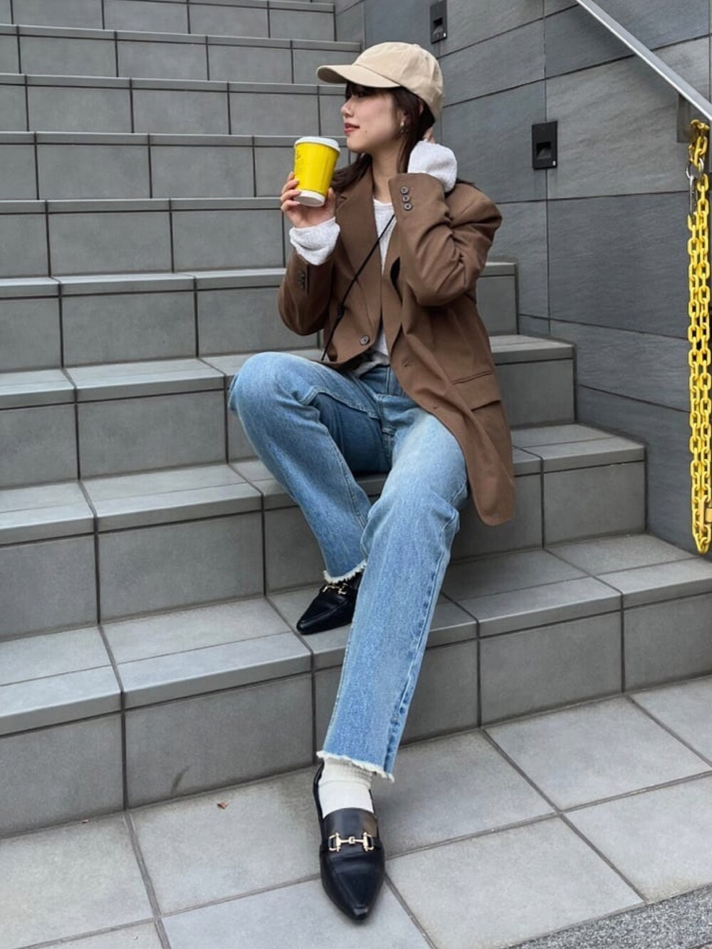 ブラウン系のテーラードジャケット、グレー系のニット/セーター、グレー系のデニムパンツを着用したレディースの冬コーディネートの2枚目の写真