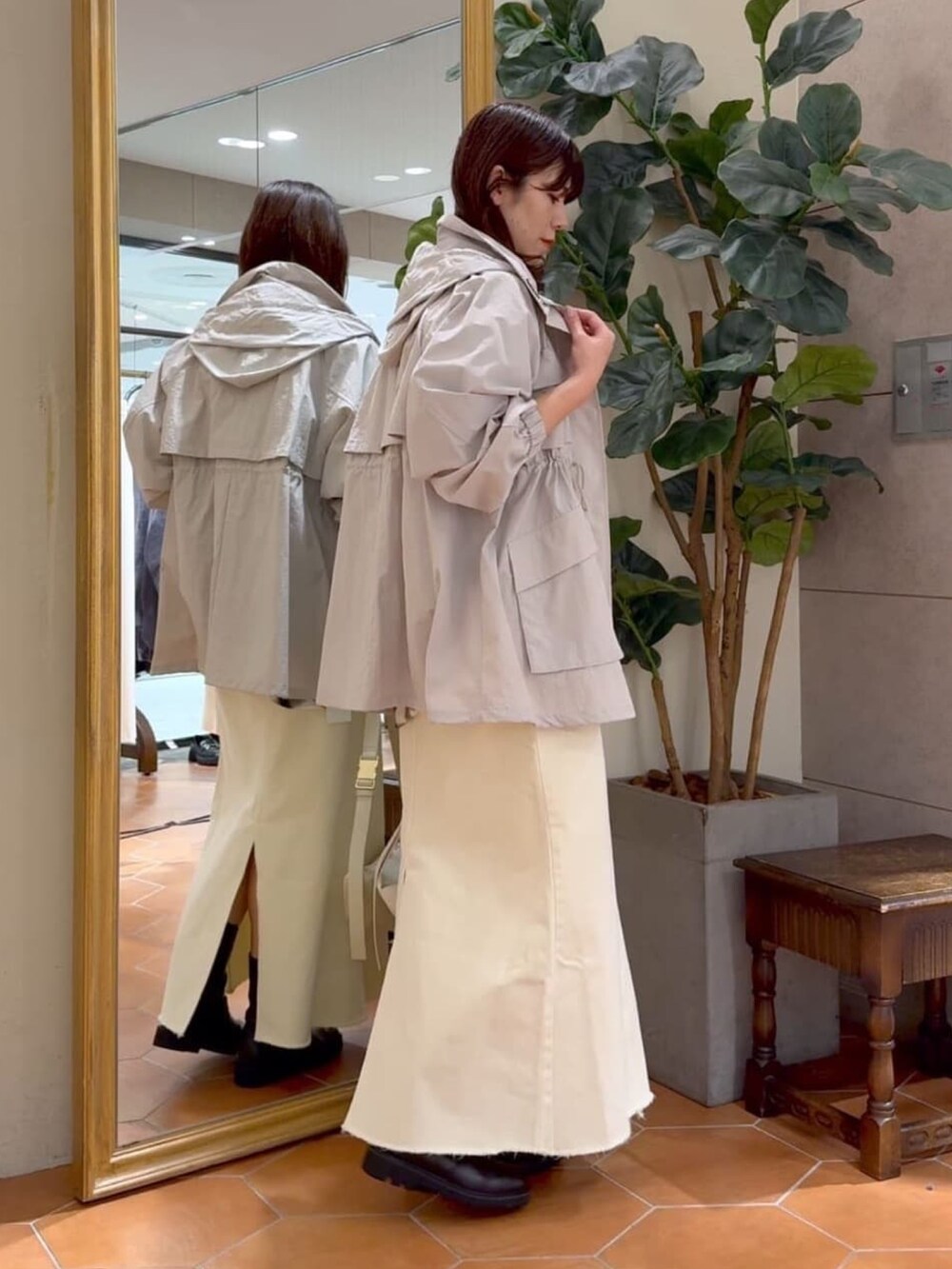 ホワイト系のシャツ/ブラウス、グレー系のマウンテンパーカー、ホワイト系のデニムスカートを着用したレディースの冬コーディネートの2枚目の写真