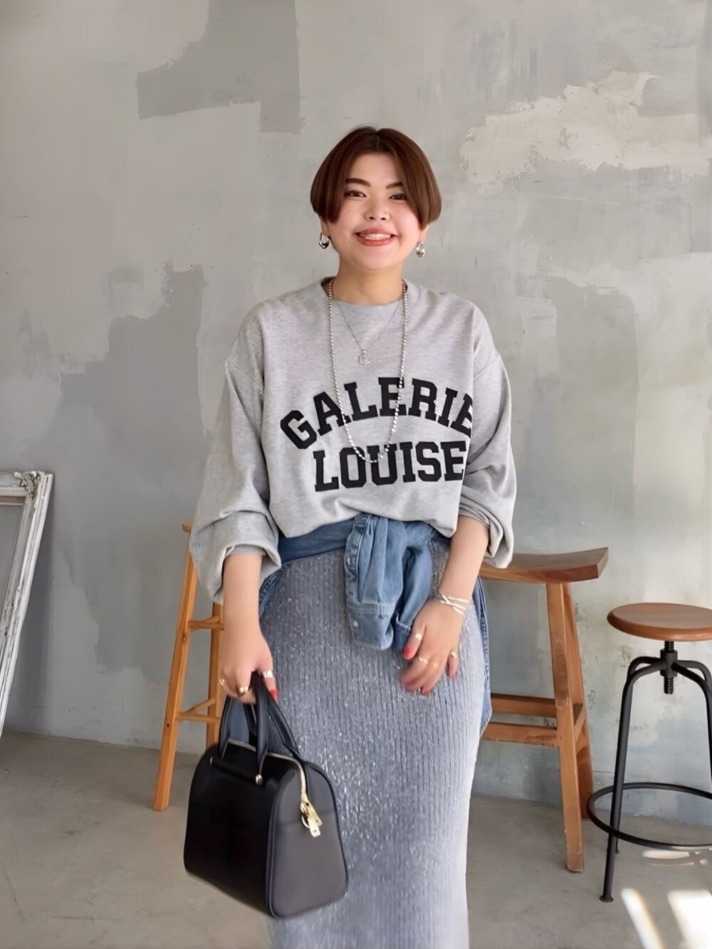 グレー系のスウェット、グレー系のスカート、ブルー系のシャツ/ブラウスを着用したレディースの秋コーディネートの4枚目の写真