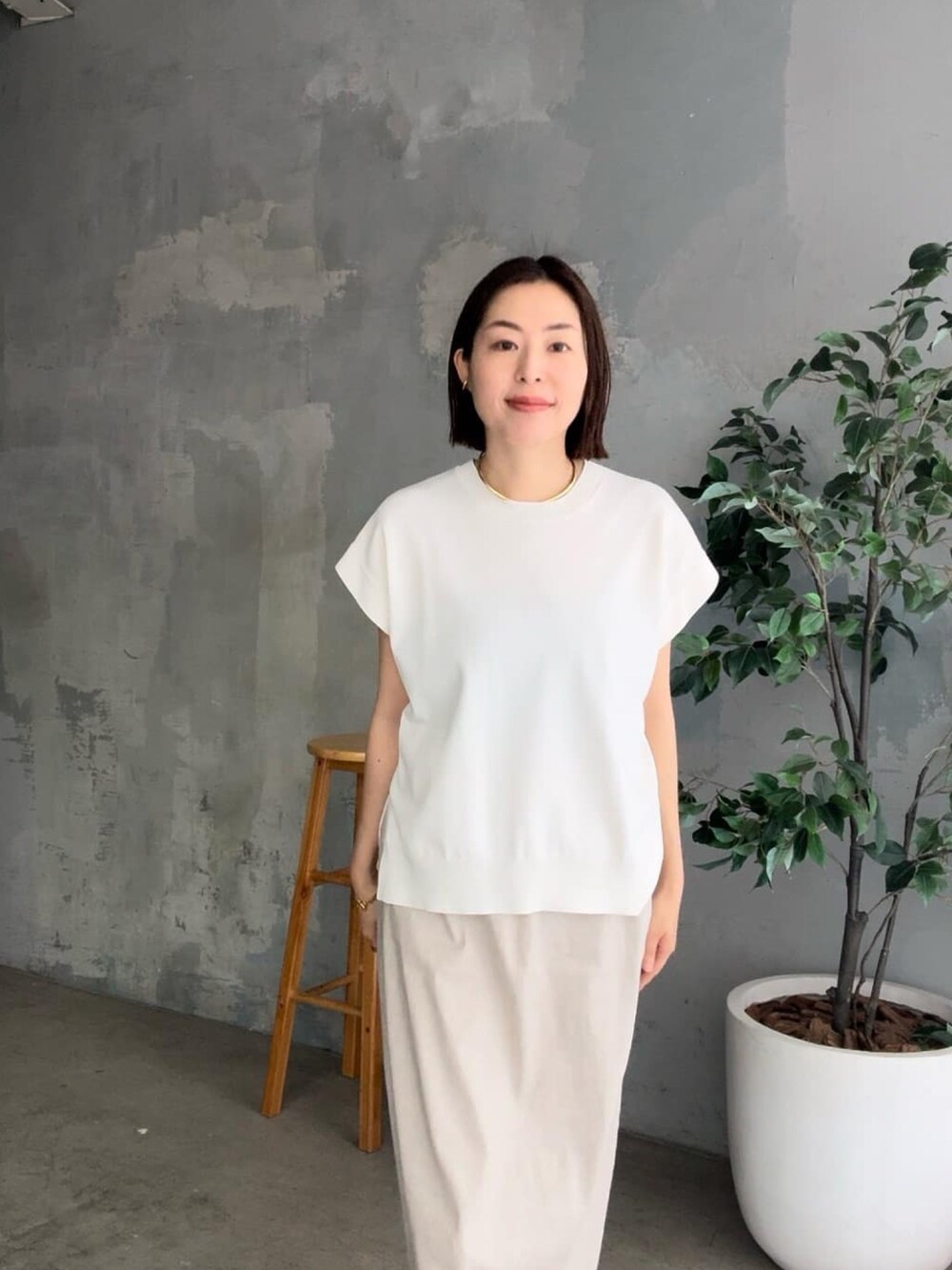 ブラック系のテーラードジャケット、ホワイト系のニット/セーター、ベージュ系のスカートを着用したレディースの春コーディネートの5枚目の写真