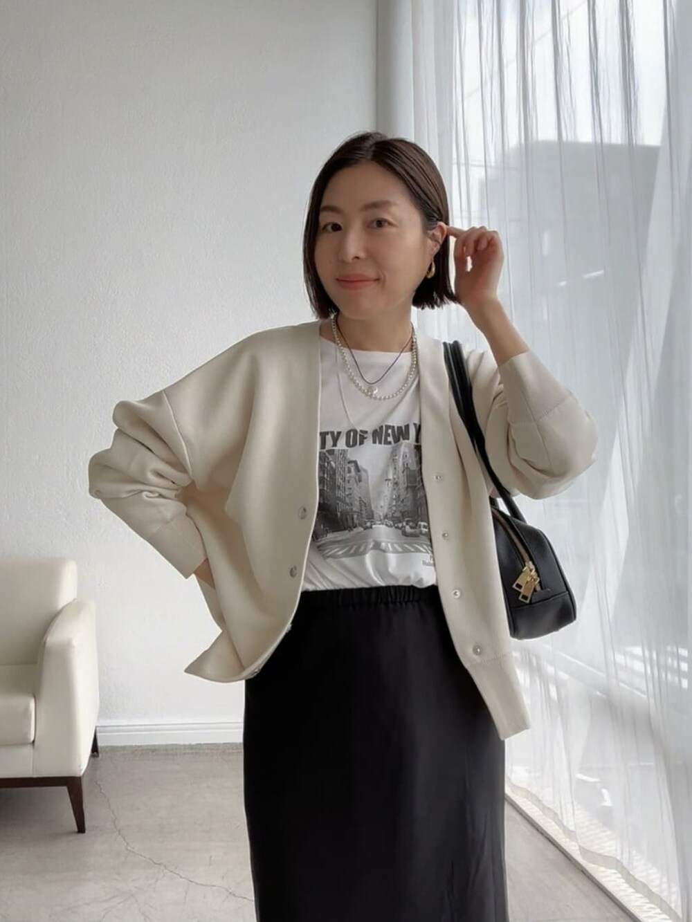 ホワイト系のTシャツ/カットソー、ホワイト系のカーディガン/ボレロ、ブラック系のスカートを着用したレディースの夏コーディネートの4枚目の写真