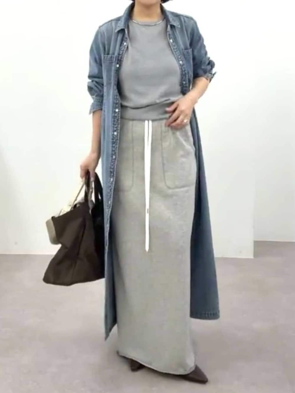 ブラウン系のその他シューズ、ブルー系のワンピース、グレー系のスカートを着用したレディースの春コーディネートの3枚目の写真