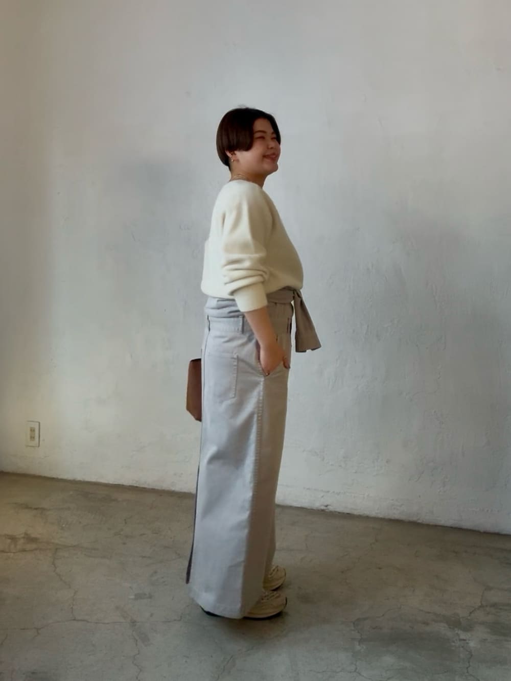 ホワイト系のニット/セーター、イエロー系のハンドバッグ、グレー系のシャツワンピースを着用したレディースの冬コーディネートの2枚目の写真