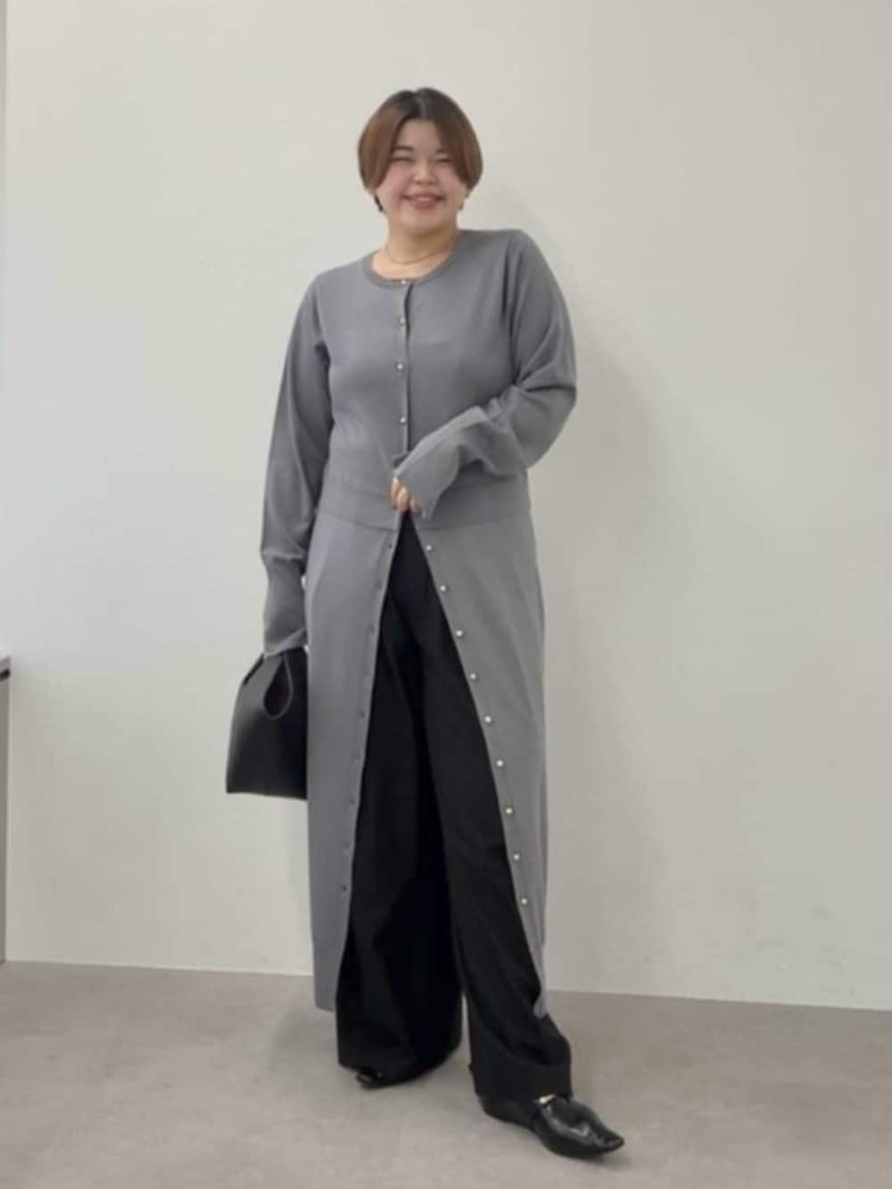 ブラック系のスラックス、ブラック系のハンドバッグ、ブラック系のその他シューズを着用したレディースの秋コーディネートの2枚目の写真