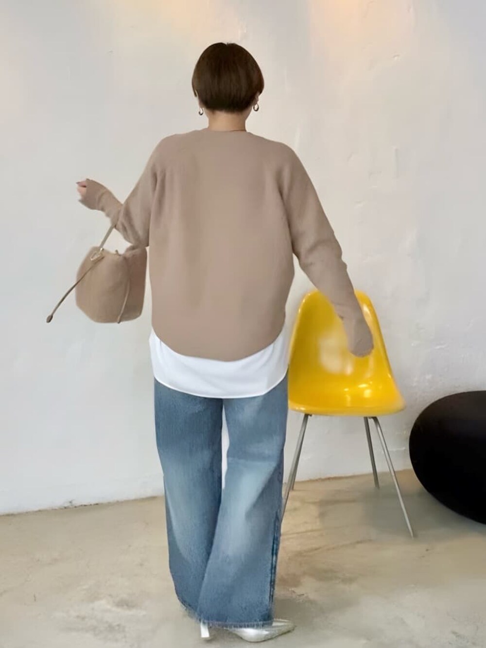 ブラウン系のニット/セーター、ブルー系のデニムパンツ、ホワイト系のシャツ/ブラウスを着用したレディースの秋コーディネートの2枚目の写真