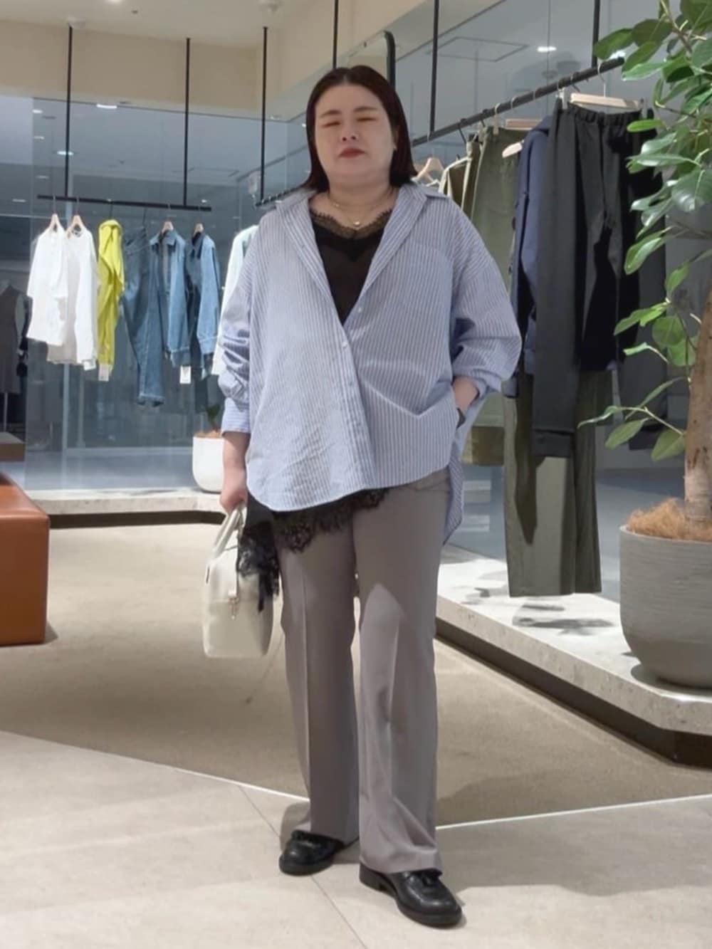 ホワイト系のボストンバッグ、ブルー系のシャツ/ブラウス、ブラック系のキャミソールを着用したレディースの春コーディネートの5枚目の写真