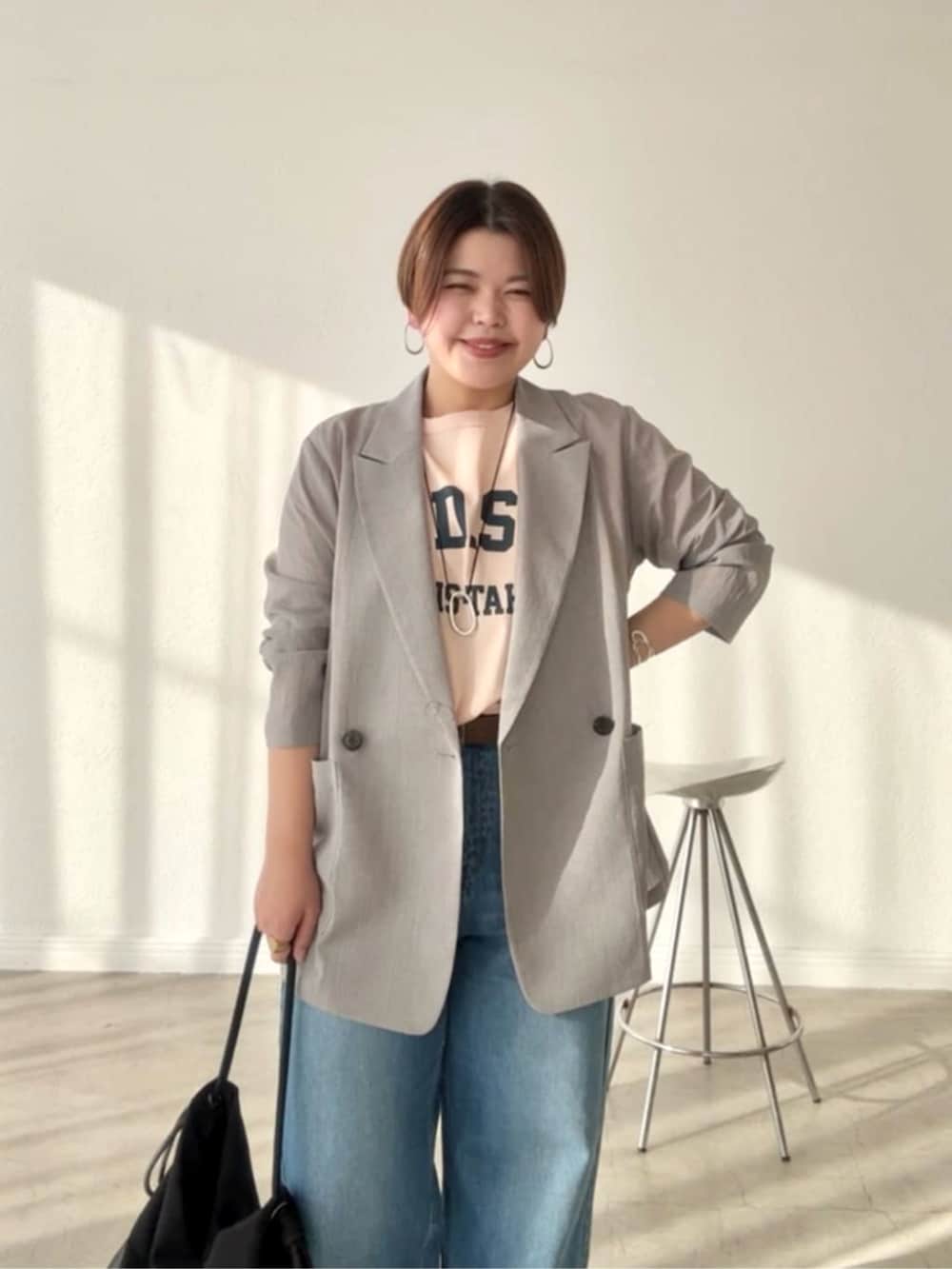 グレー系のテーラードジャケット、ブルー系のデニムパンツ、ベージュ系のその他シューズを着用したレディースの春コーディネートの3枚目の写真