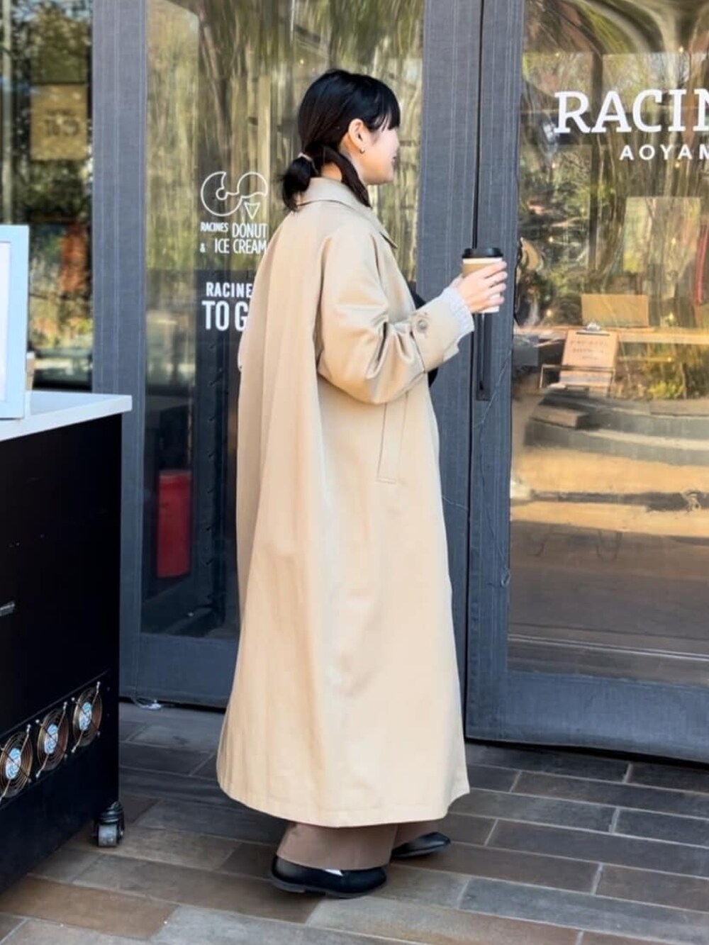 グレー系のカーディガン/ボレロ、ホワイト系のTシャツ/カットソー、ブラウン系のステンカラーコートを着用したレディースの冬コーディネートの2枚目の写真