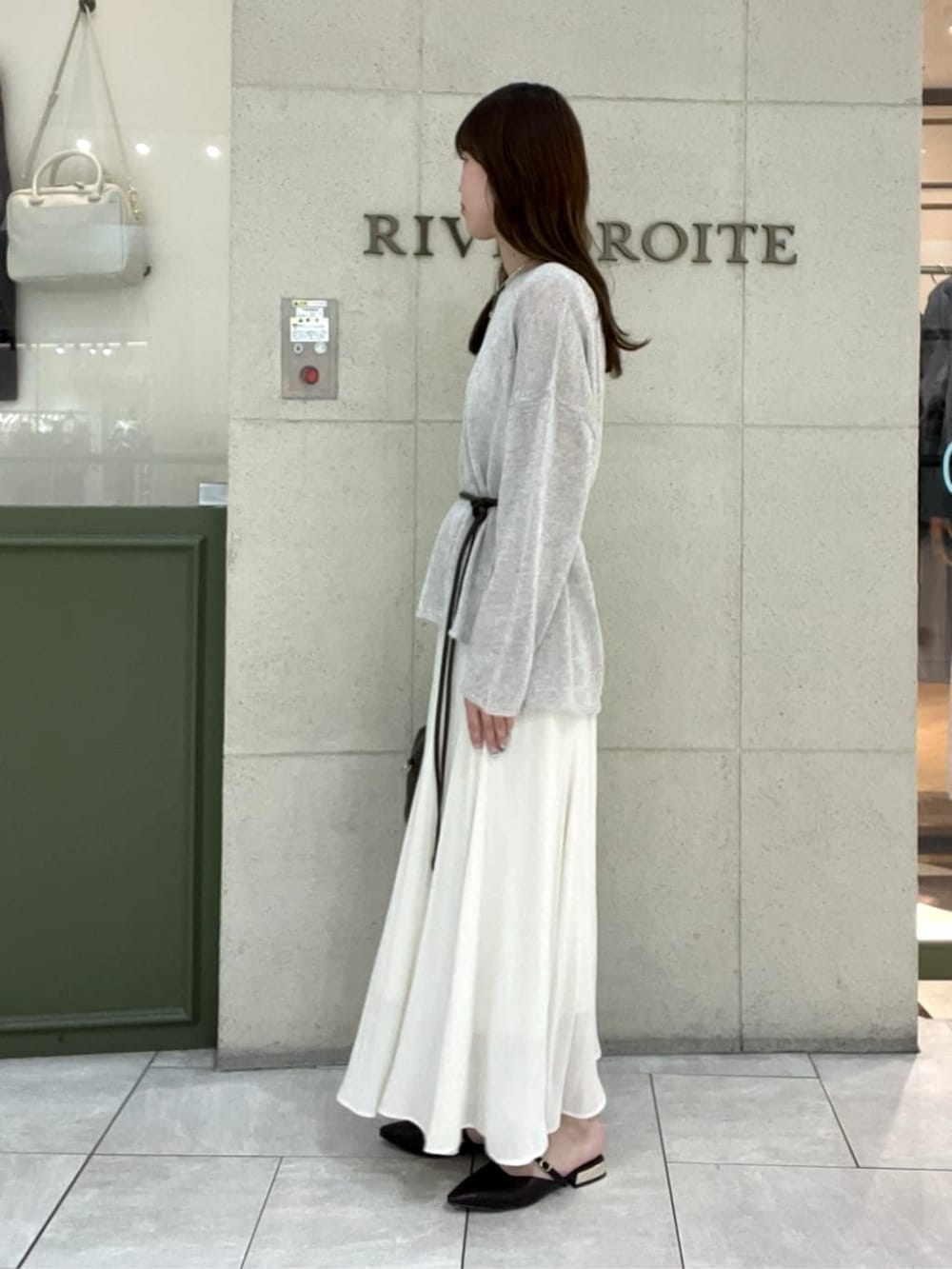 ブラウン系のその他シューズ、ブラウン系のボストンバッグ、ベージュ系のスカートを着用したレディースの春コーディネートの2枚目の写真