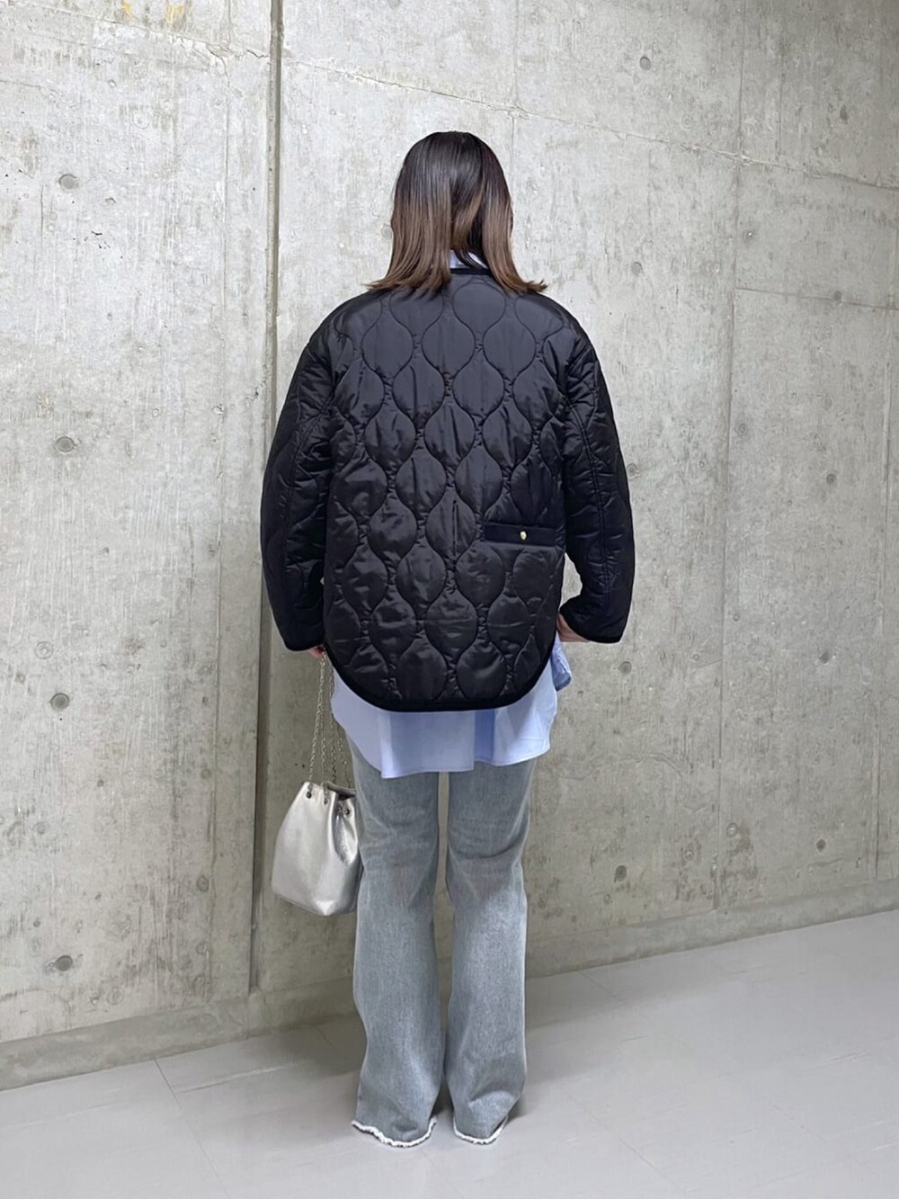 ブルー系のデニムパンツ、グレー系のニット/セーター、シルバー系のショルダーバッグを着用したレディースの秋コーディネートの3枚目の写真