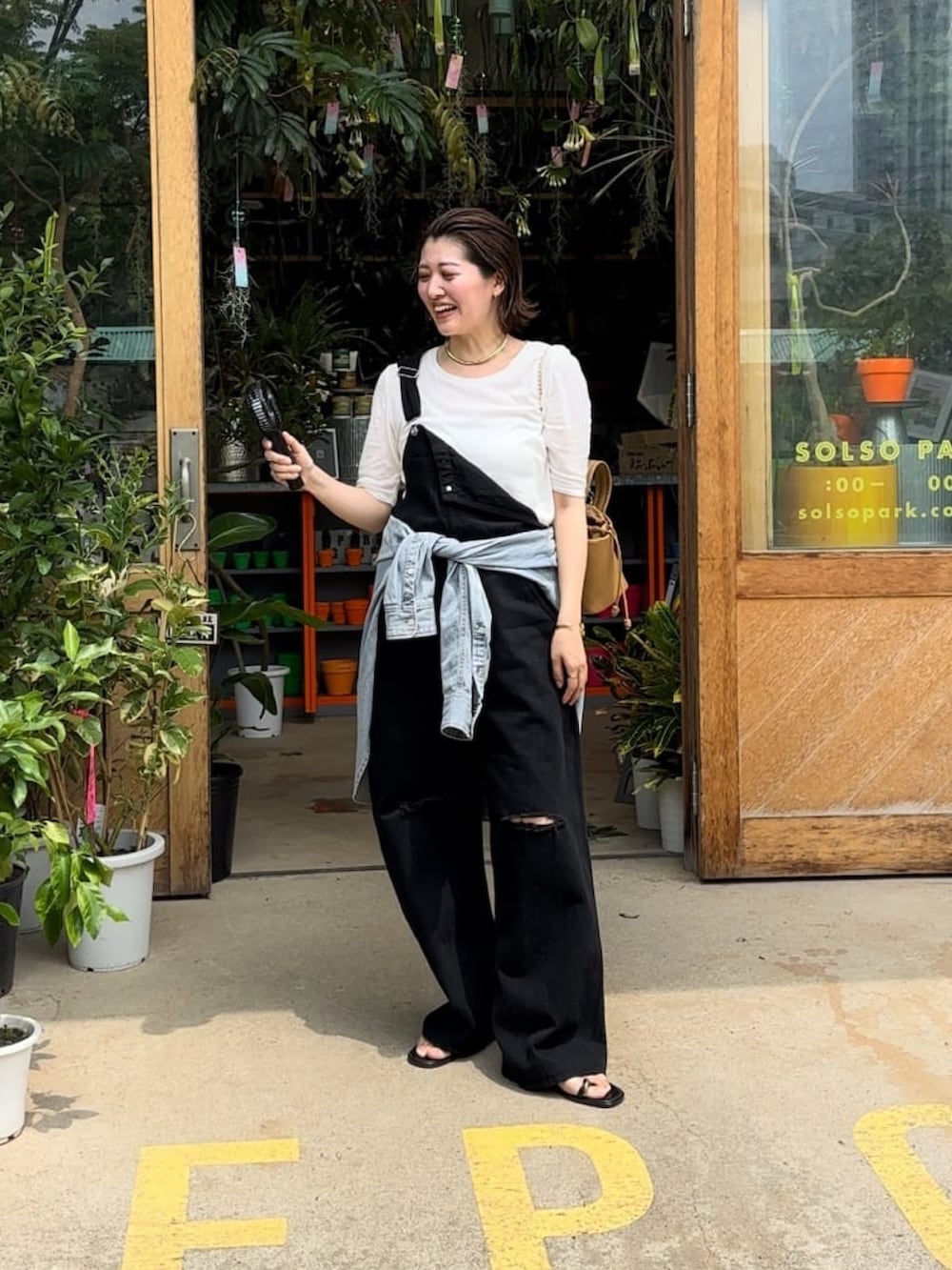 ホワイト系のTシャツ/カットソー、ブラック系のサロペット/オーバーオール、イエロー系のハンドバッグを着用したレディースの夏コーディネートの4枚目の写真