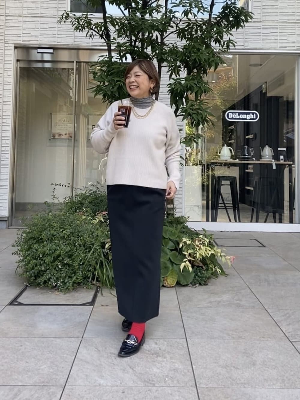 ベージュ系のニット/セーター、ブラック系のスカートを着用したレディースの冬コーディネートの2枚目の写真