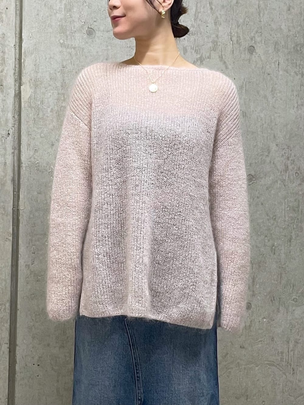 ピンク系のニット/セーター、ブルー系のデニムスカート、ブラウン系のブーツを着用したレディースの秋コーディネートの4枚目の写真