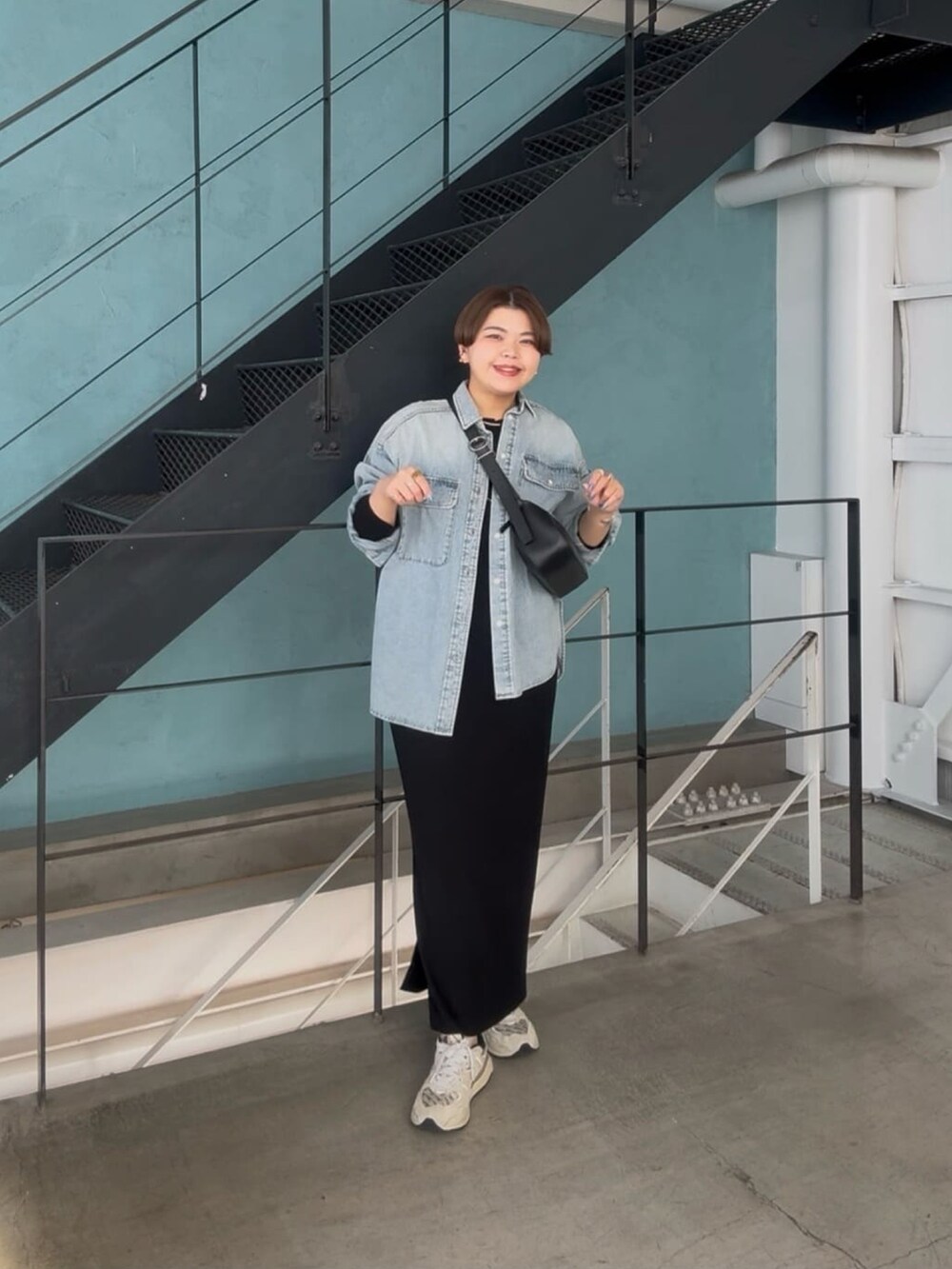 ブラック系のボディバッグ/ウエストポーチ、ブルー系のシャツ/ブラウス、ブラック系のワンピースを着用したレディースの冬コーディネートの4枚目の写真