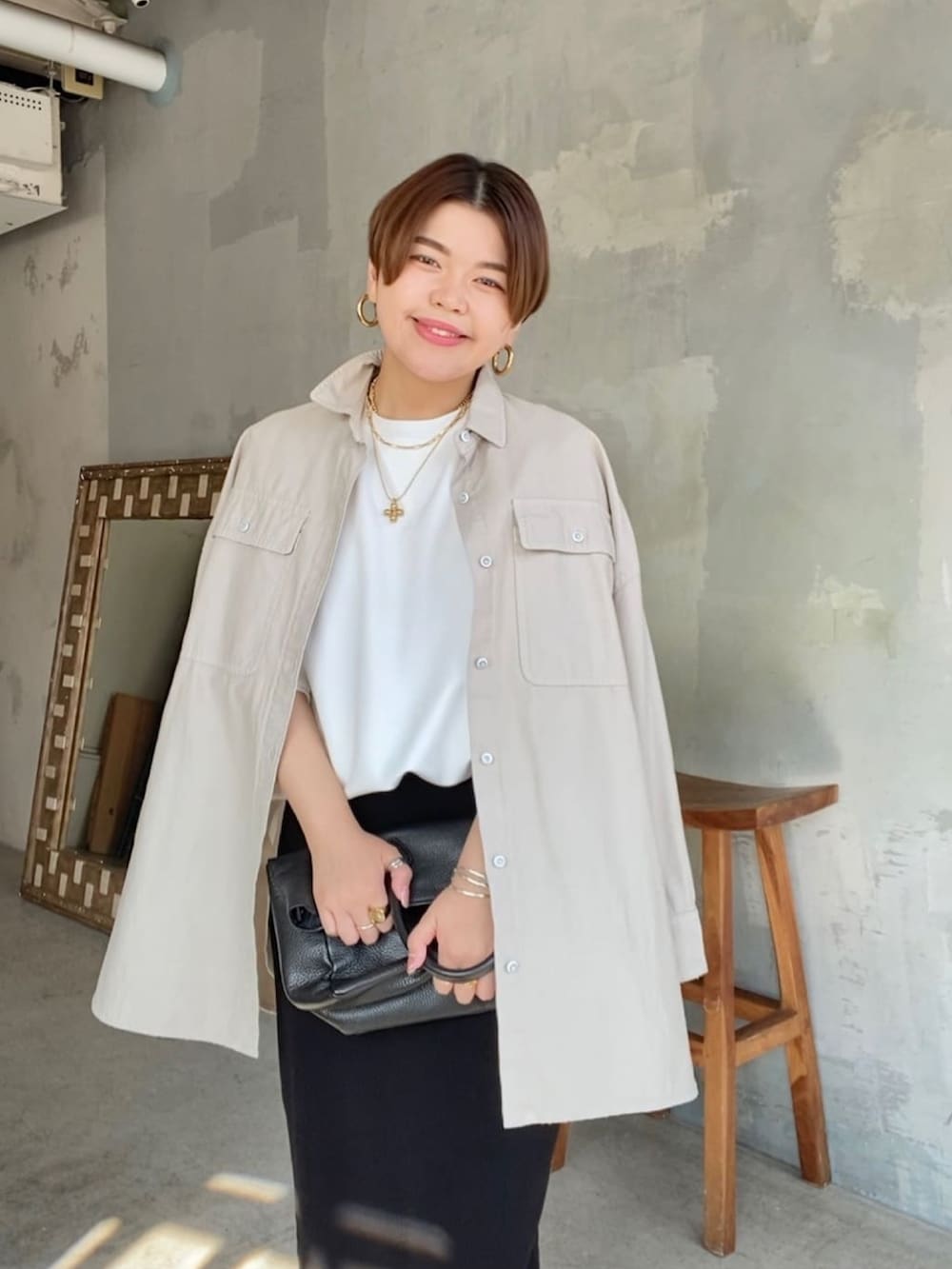 ブラック系のスカート、ホワイト系のTシャツ/カットソー、ブラック系のブーツを着用したレディースの冬コーディネートの3枚目の写真