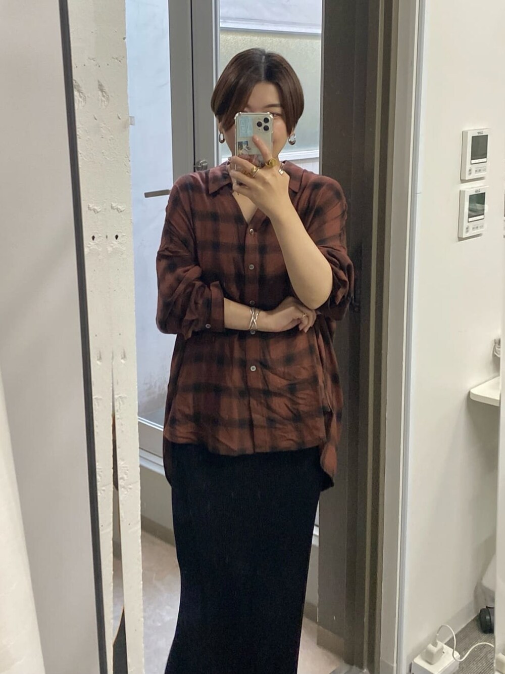 ブラック系のスカート、ブラック系のサンダル、ブラウン系のシャツ/ブラウスを着用したレディースの夏コーディネートの2枚目の写真