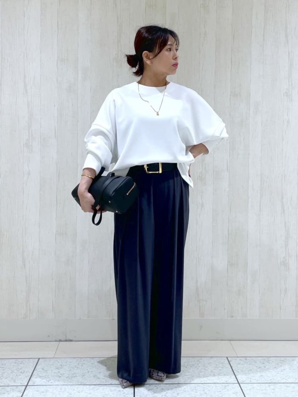 ホワイト系のTシャツ/カットソー、ブラック系のショルダーバッグ、グレー系のパンプスを着用したレディースの冬コーディネートの5枚目の写真