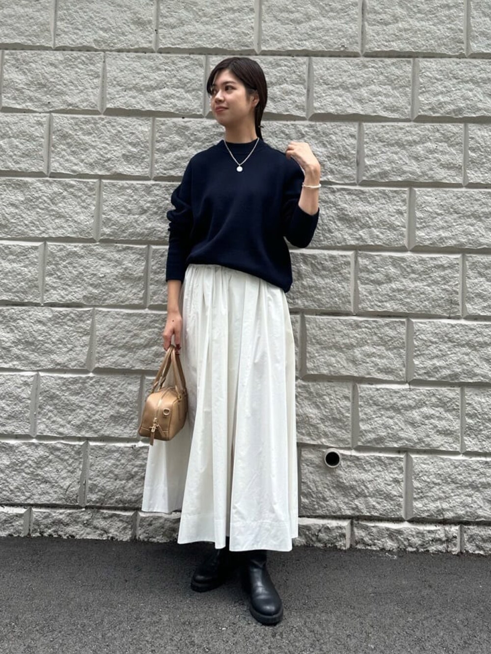 ホワイト系のスカート、ブルー系のニット/セーター、ブラック系のブーツを着用したレディースの秋コーディネートの2枚目の写真